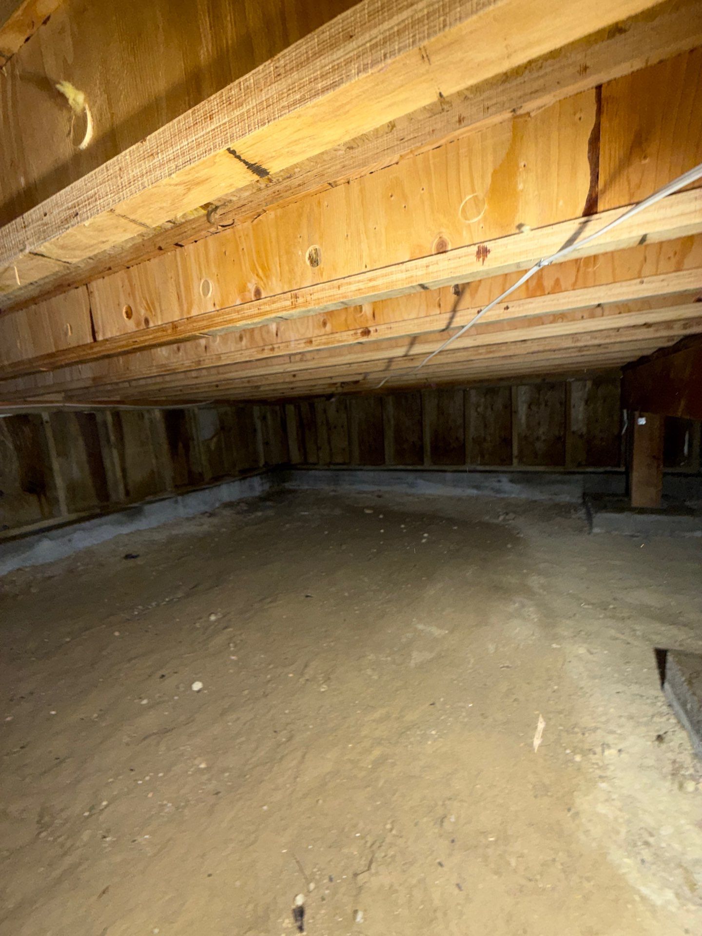 Dirt-floor crawlspace with exposed floor joists in a Summit County Colorado home